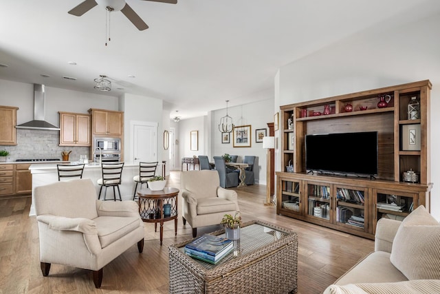 living room featuring ceiling fan and light hardwood / wood-style floors