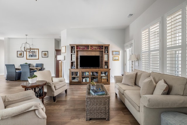 living room with dark hardwood / wood-style flooring and an inviting chandelier