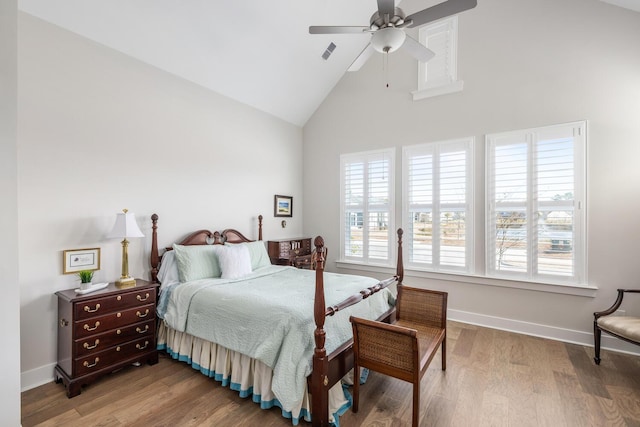 bedroom featuring ceiling fan, wood-type flooring, and high vaulted ceiling