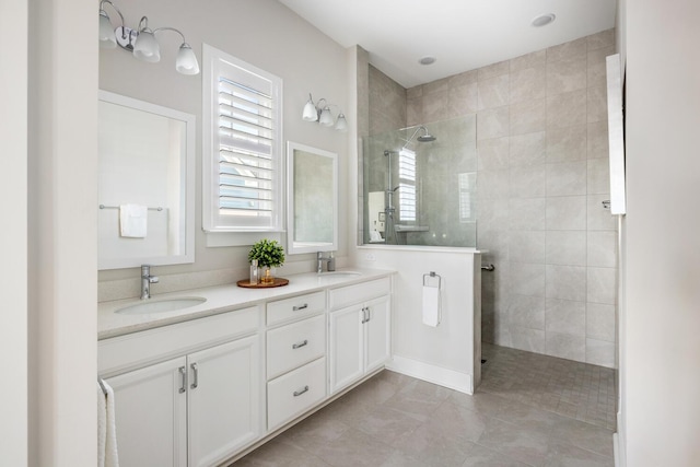 bathroom with vanity, tile patterned flooring, and a tile shower