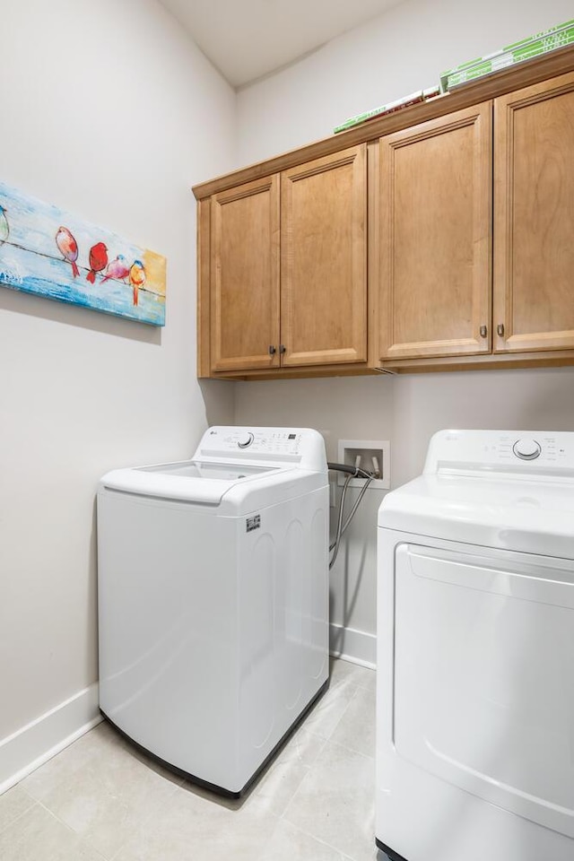 laundry area featuring washing machine and clothes dryer and cabinets