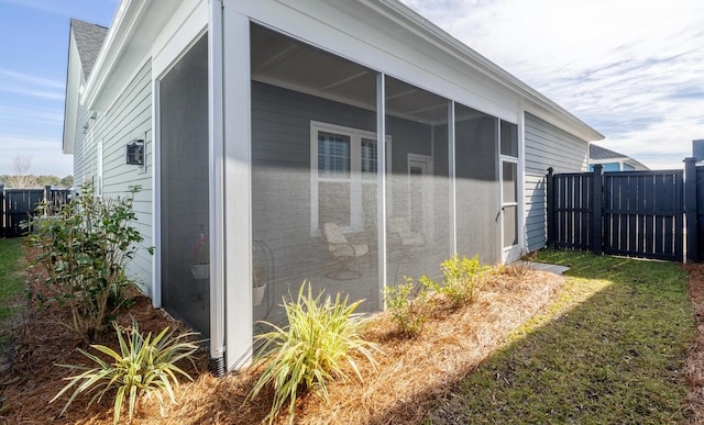 view of property exterior with a sunroom and a lawn