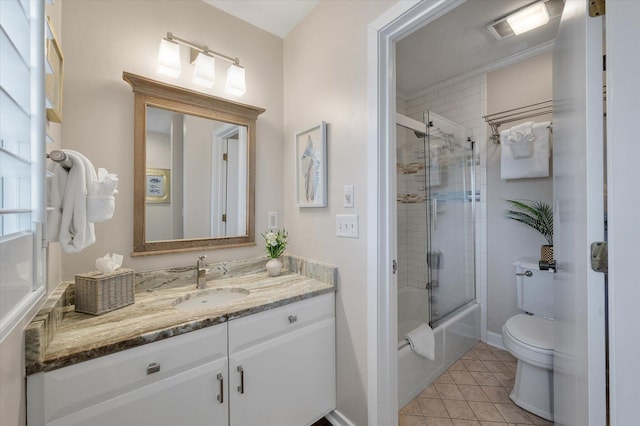 bathroom with visible vents, toilet, combined bath / shower with glass door, vanity, and tile patterned flooring