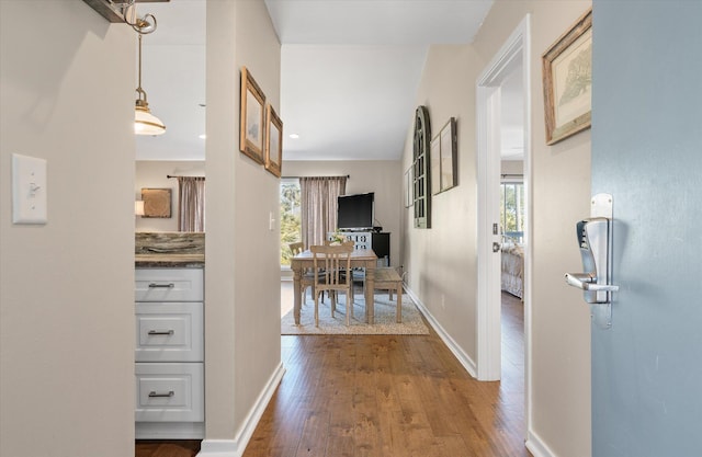 corridor featuring a wealth of natural light, baseboards, dark wood-style flooring, and recessed lighting