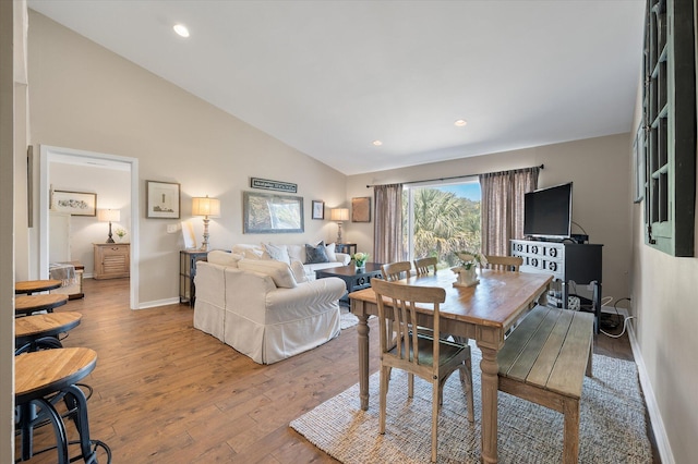 dining room featuring high vaulted ceiling, baseboards, wood finished floors, and recessed lighting