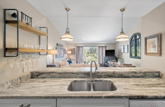 kitchen with lofted ceiling, pendant lighting, a sink, and open shelves