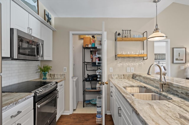 kitchen featuring black / electric stove, a sink, white cabinetry, backsplash, and stainless steel microwave