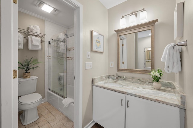 bathroom featuring baseboards, toilet, enclosed tub / shower combo, tile patterned floors, and vanity