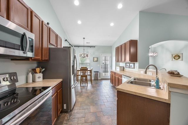 201 Maywood Dr, Moncks Corner, SC 29461 - kitchen featuring appliances with stainless steel finishes, stone tile floors, vaulted ceiling, a peninsula, and light countertops