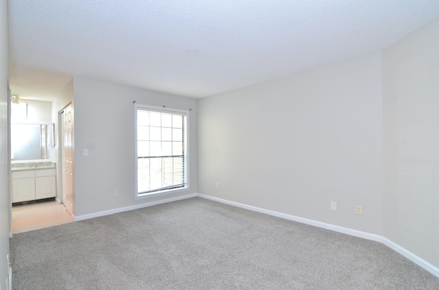 carpeted empty room featuring a textured ceiling