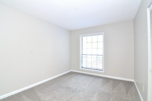 carpeted empty room with a textured ceiling