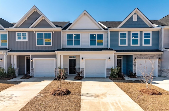 view of property featuring a garage, concrete driveway, board and batten siding, and stone siding