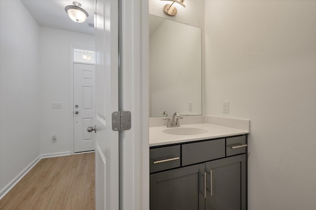 bathroom featuring baseboards, wood finished floors, and vanity