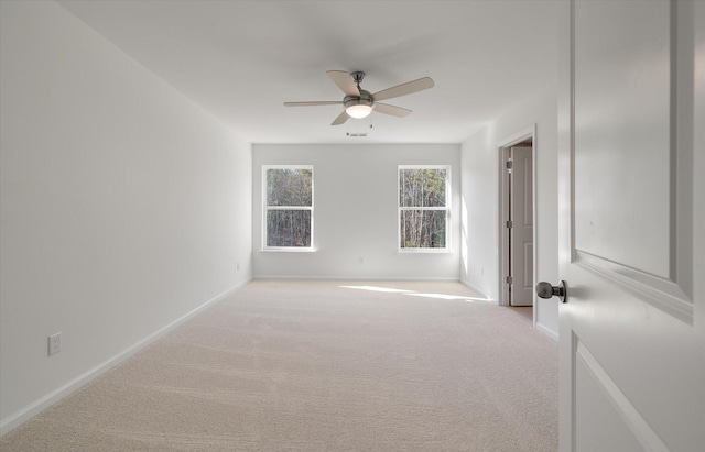 empty room with a ceiling fan, light carpet, visible vents, and baseboards