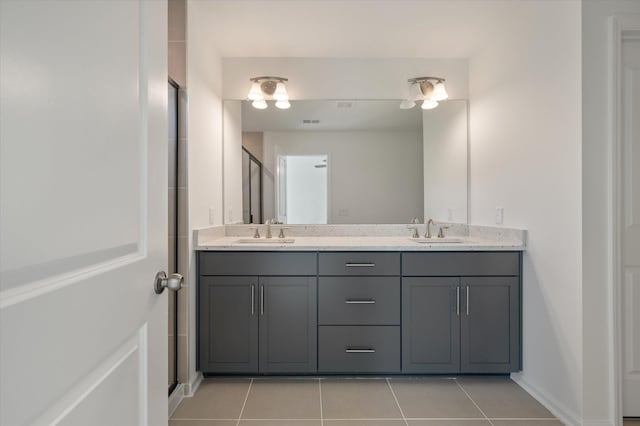 bathroom with double vanity, a sink, and tile patterned floors