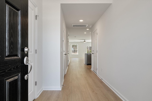 hallway with light wood-style flooring, recessed lighting, visible vents, and baseboards