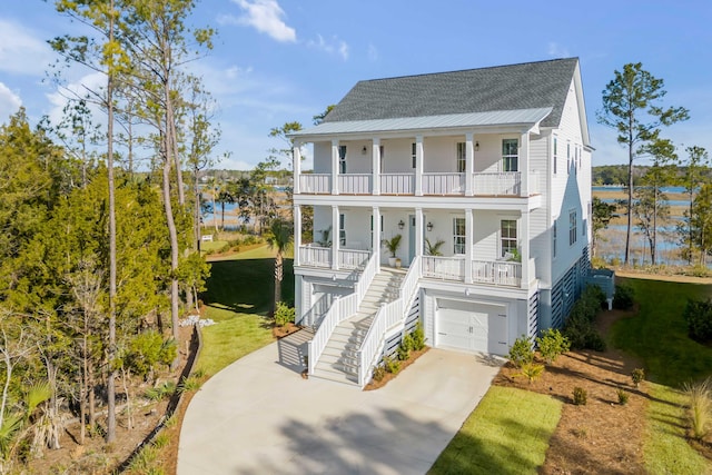 coastal inspired home with a garage, a balcony, and a porch