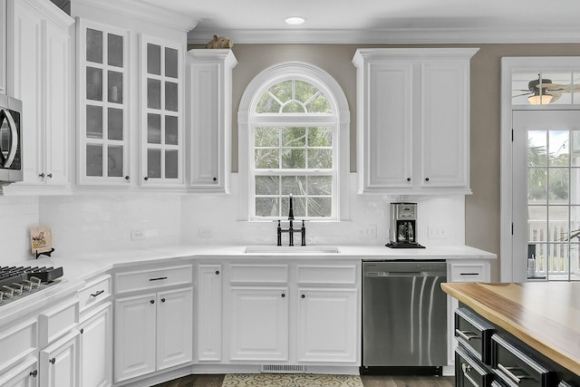 kitchen with stainless steel appliances, a sink, and white cabinets