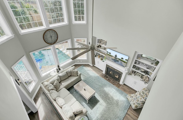 living area featuring a high ceiling, wood finished floors, and a high end fireplace