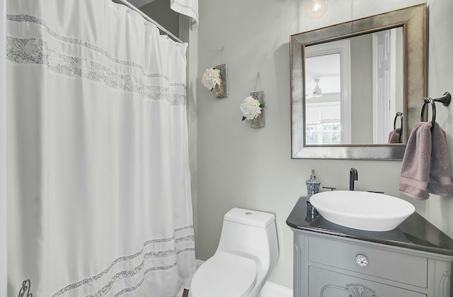 bathroom featuring a shower with shower curtain, vanity, and toilet