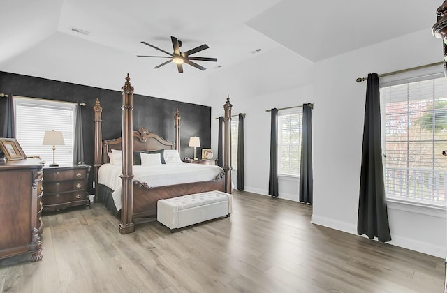 bedroom featuring visible vents, baseboards, vaulted ceiling, and wood finished floors