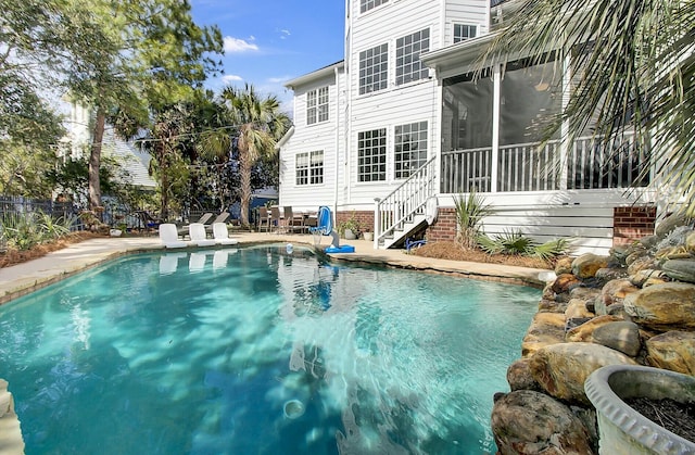 view of swimming pool featuring a fenced in pool, a sunroom, a patio, and fence