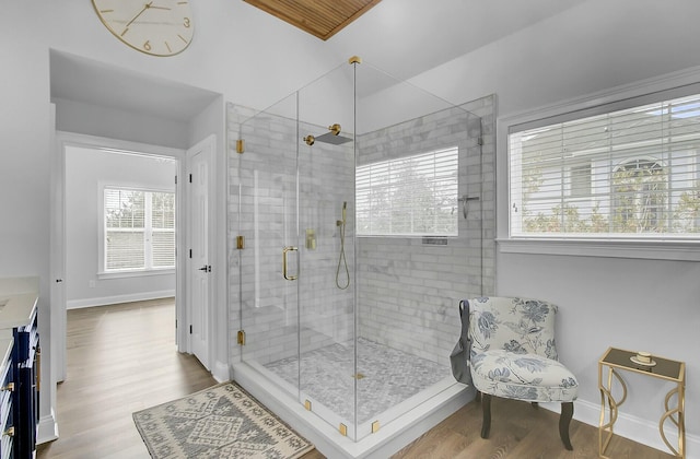 full bathroom with a shower stall, baseboards, and wood finished floors