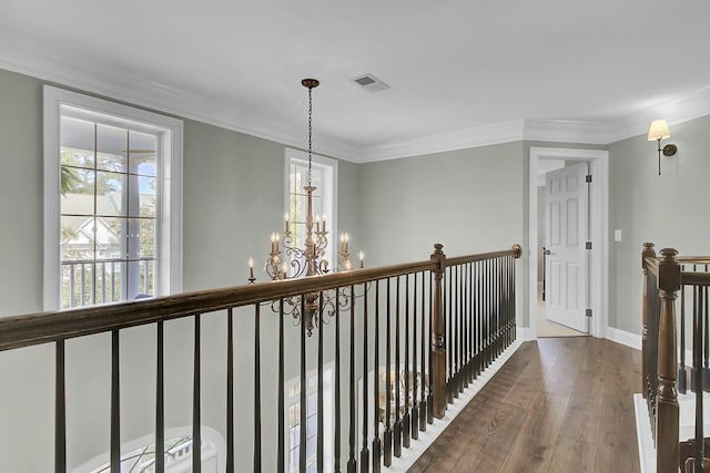 corridor with visible vents, plenty of natural light, an upstairs landing, and wood finished floors