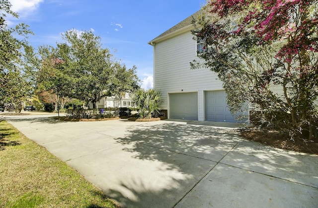 view of side of home with driveway and a garage