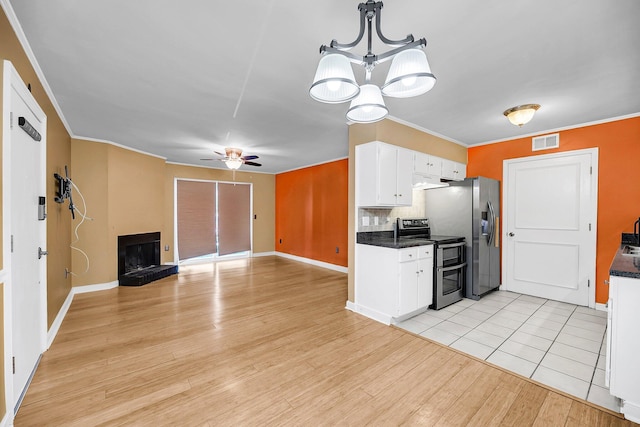 kitchen featuring visible vents, white cabinets, a fireplace with raised hearth, appliances with stainless steel finishes, and light wood-type flooring