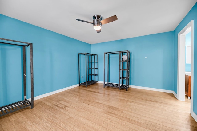 empty room featuring light wood-type flooring, baseboards, and a ceiling fan