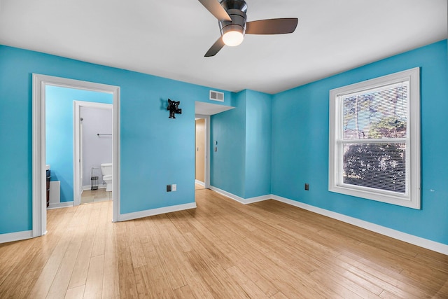 unfurnished bedroom with a ceiling fan, visible vents, baseboards, and wood finished floors