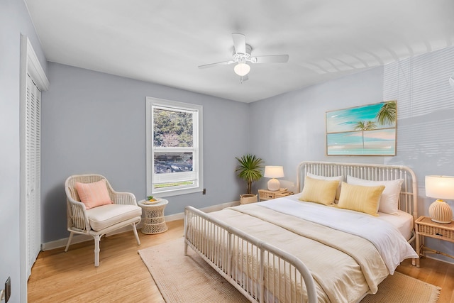 bedroom featuring light wood finished floors, a closet, a ceiling fan, and baseboards