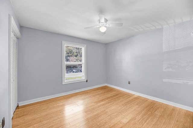 unfurnished bedroom featuring light wood-type flooring, a ceiling fan, baseboards, and a closet