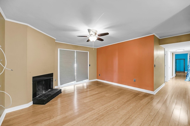 unfurnished living room featuring light wood-style floors, a fireplace, baseboards, and crown molding