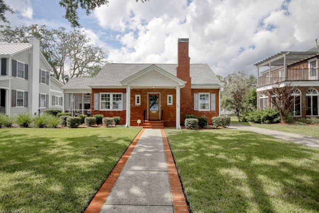 104 E Bay St, Georgetown, SC 29440 - view of front facade featuring a front yard, brick siding, a chimney, and a shingled roof