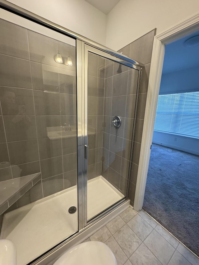 bathroom with a stall shower and tile patterned flooring