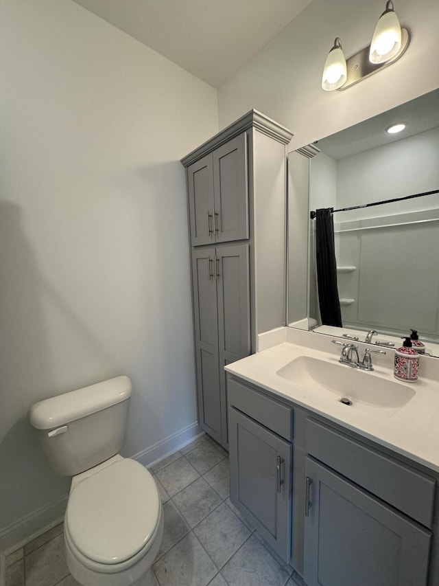 bathroom featuring baseboards, vanity, toilet, and tile patterned floors