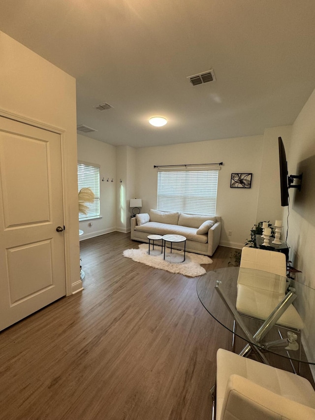 living area featuring plenty of natural light, wood finished floors, and visible vents