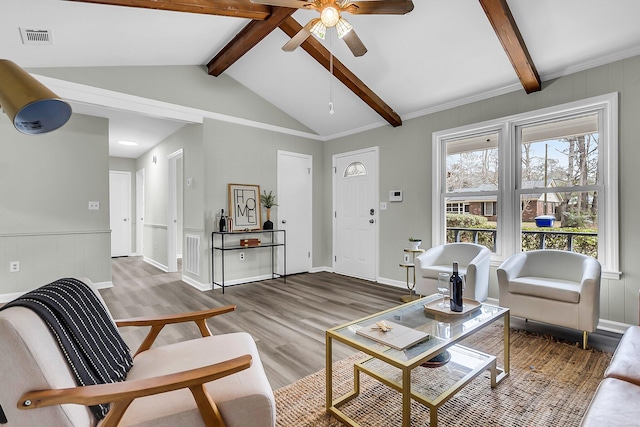 living area featuring visible vents, baseboards, lofted ceiling with beams, wood finished floors, and a ceiling fan