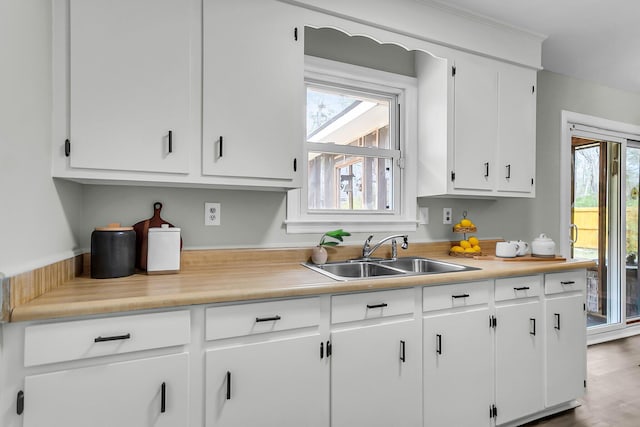 kitchen with a sink, white cabinets, and light countertops