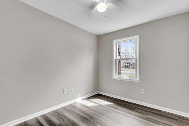 empty room featuring ceiling fan, baseboards, and wood finished floors