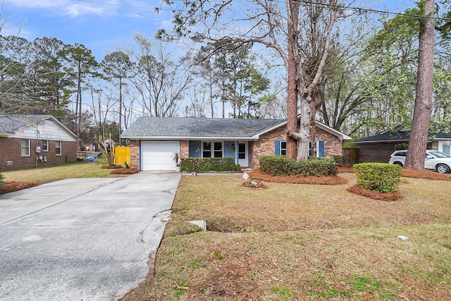 view of front of house featuring a front yard, concrete driveway, brick siding, and a garage