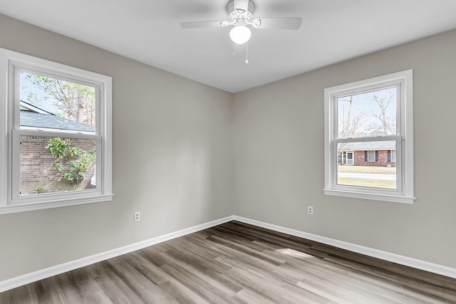 spare room with ceiling fan, baseboards, and wood finished floors