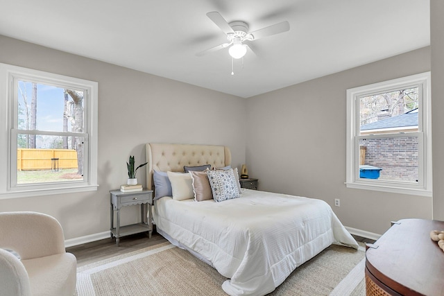 bedroom with baseboards, wood finished floors, and a ceiling fan