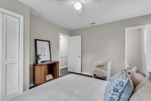 bedroom with visible vents, a ceiling fan, wood finished floors, a closet, and baseboards