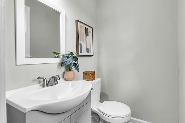 bathroom featuring vanity, toilet, and baseboards