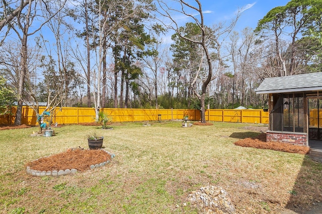 view of yard featuring a fenced backyard and a sunroom