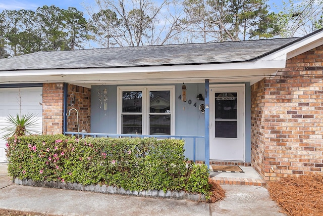 property entrance with brick siding, a porch, a shingled roof, and a garage