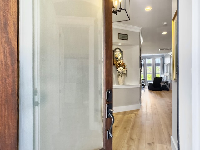 hall with visible vents, recessed lighting, light wood-style floors, crown molding, and baseboards